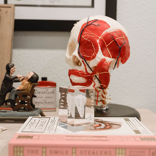 Sparks, NV dentist Dr. Kanellis a 3D modal of teeth on top of a book.