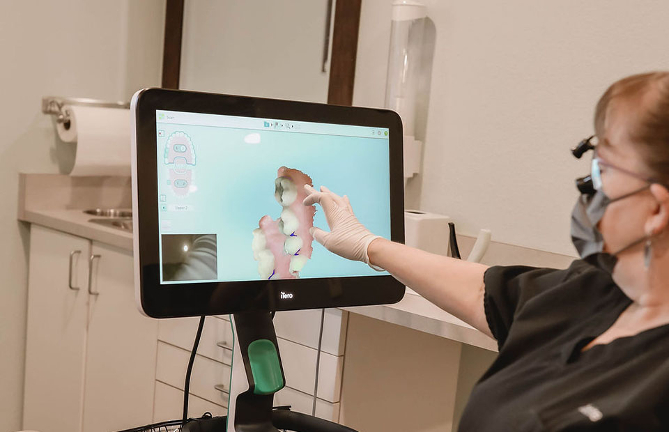 Sparks, NV Dr. Kanellis staff member pointing at a computer screen while consulting a patient.