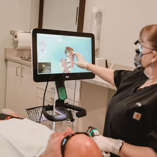 Sparks, NV Dr. Kanellis staff member pointing at a computer screen while consulting a patient.